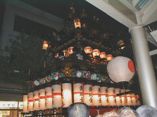 A float pulled through the streets, lit by lanterns.