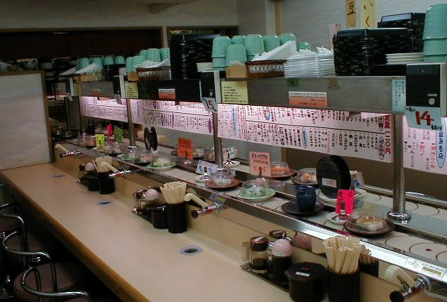Watch the sushi go round and round on the conveyor belt.